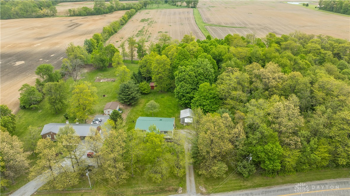 1319 Perry Road Cable, OH 43009 - Photo 5 of 44 This aerial view showcases a serene property nestled amidst lush trees and expansive fields.