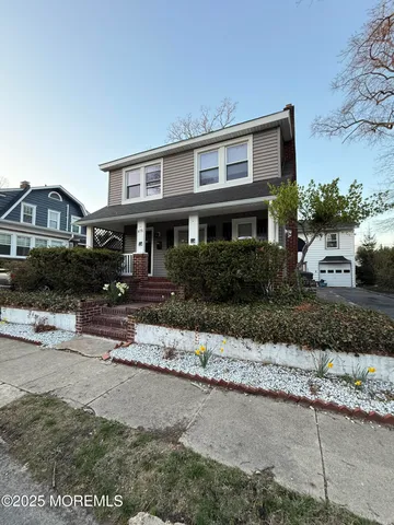 a front view of a house with a garden and yard