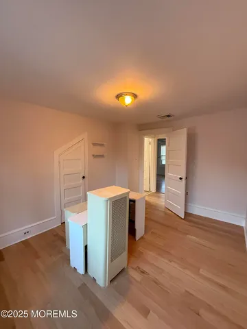 a view of a room with wooden floor and window