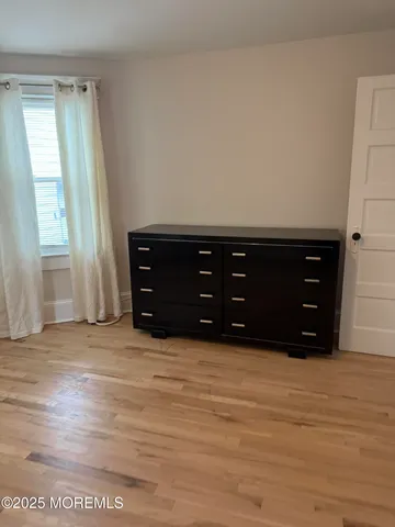 a room with a dresser and a window