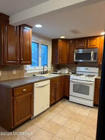 a kitchen with a stove a sink and a microwave