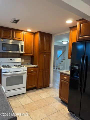 a kitchen with a stove a refrigerator and a sink