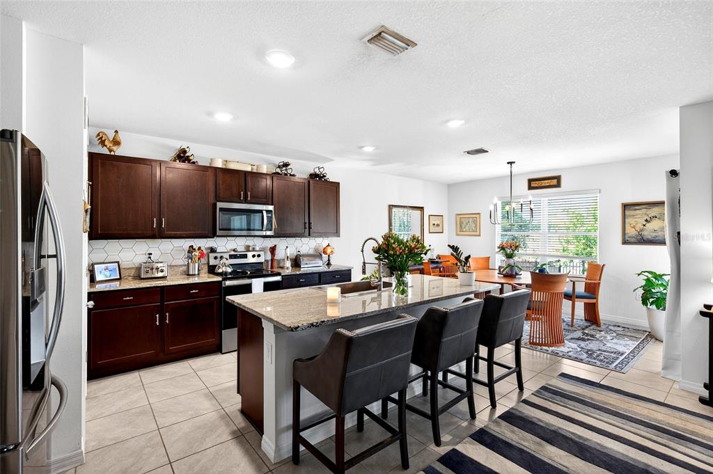 508 Hickory Course Loop Ocala, FL 34472 - Photo 29 of 40 a kitchen with stainless steel appliances a stove a sink a microwave a dining table and chairs