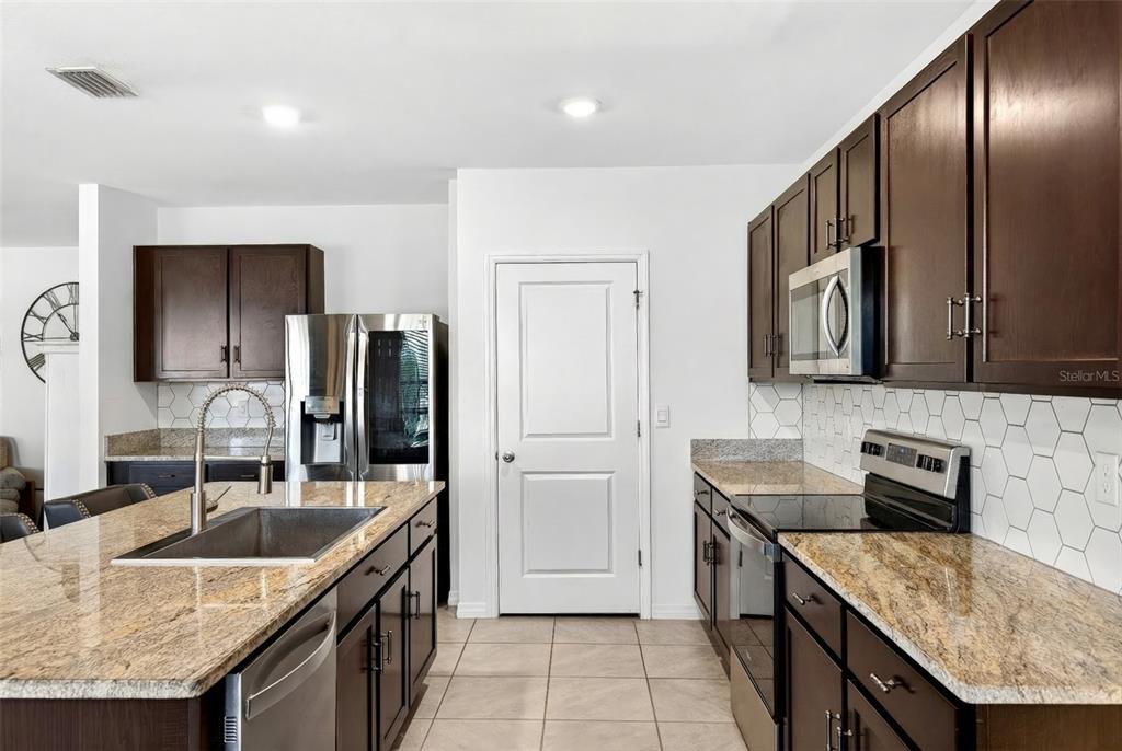 508 Hickory Course Loop Ocala, FL 34472 - Photo 31 of 40 a kitchen with stainless steel appliances granite countertop a sink stove and refrigerator