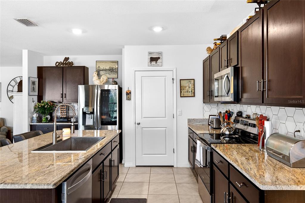 508 Hickory Course Loop Ocala, FL 34472 - Photo 32 of 40 a kitchen with stainless steel appliances granite countertop a sink a stove and a refrigerator
