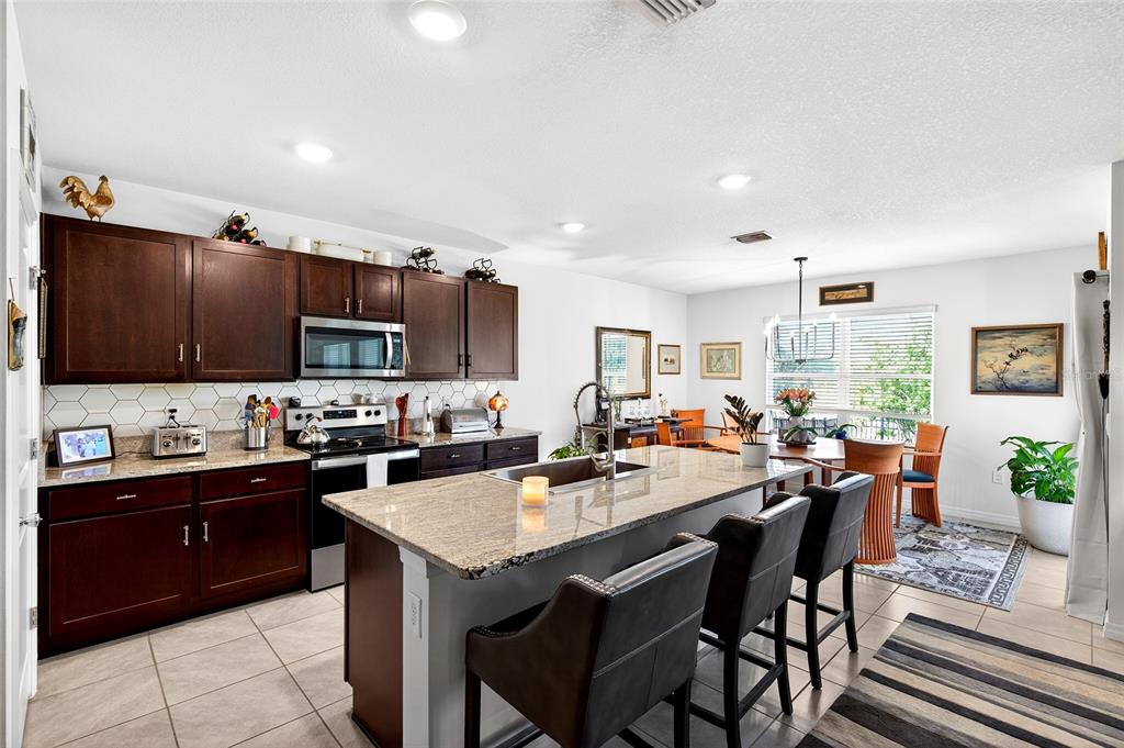 508 Hickory Course Loop Ocala, FL 34472 - Photo 34 of 40 a kitchen with sink a refrigerator and chairs