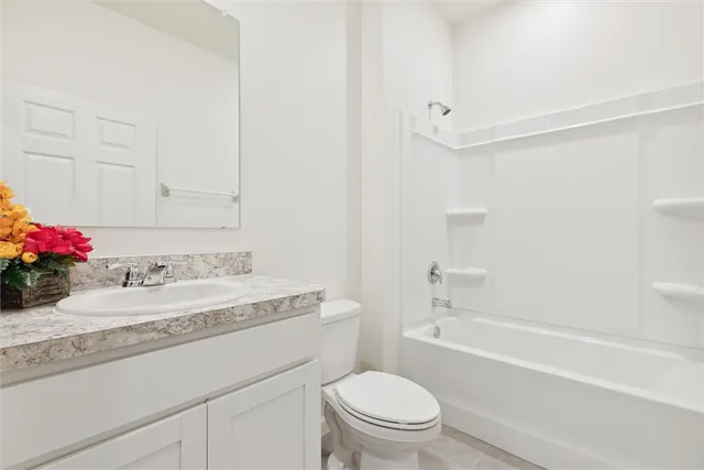 a bathroom with a granite countertop sink a toilet and shower