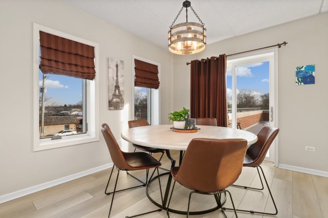 225 Main Street, Unit 214 Roselle, IL 60172 - Photo 11 of 27 a view of a dining room with furniture wooden floor and chandelier