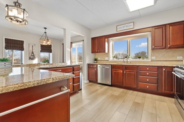 225 Main Street, Unit 214 Roselle, IL 60172 - Photo 6 of 27 a large kitchen with stainless steel appliances granite countertop a stove sink and cabinets