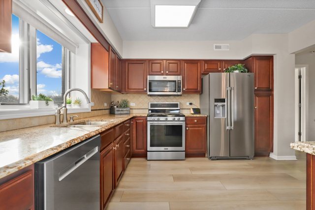 225 Main Street, Unit 214 Roselle, IL 60172 - Photo 8 of 27 a kitchen with stainless steel appliances granite countertop a refrigerator stove and sink