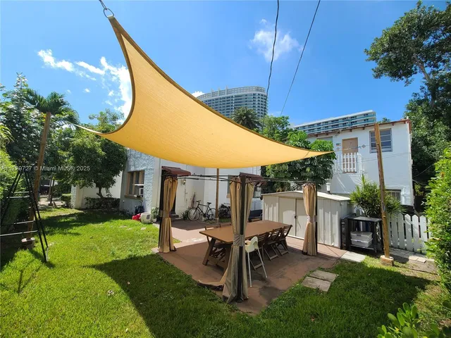 a backyard of a house with table and chairs