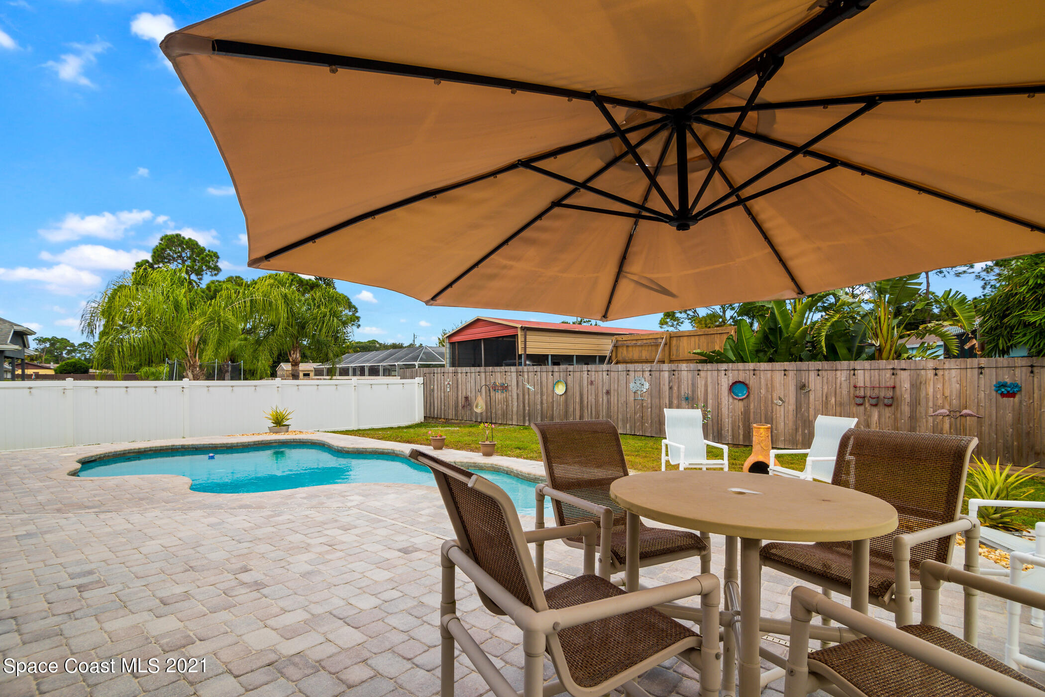 6336 Hudson Road Cocoa, FL 32927 - Photo 22 of 24 a patio with a table and chairs under an umbrella