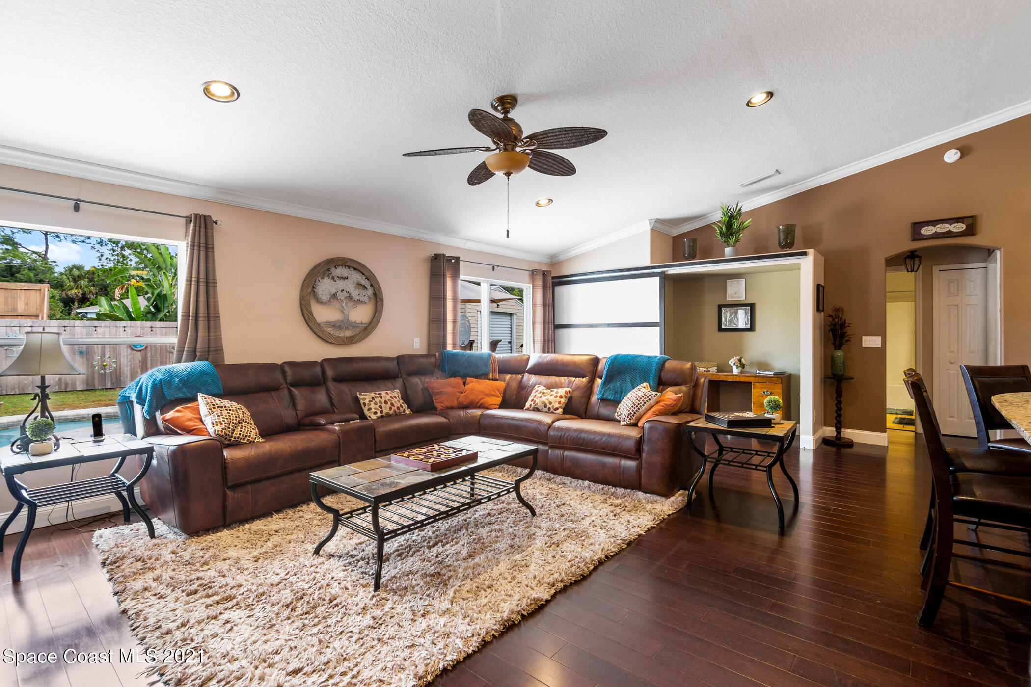 6336 Hudson Road Cocoa, FL 32927 - Photo 9 of 24 a living room with furniture a clock on wall and a window