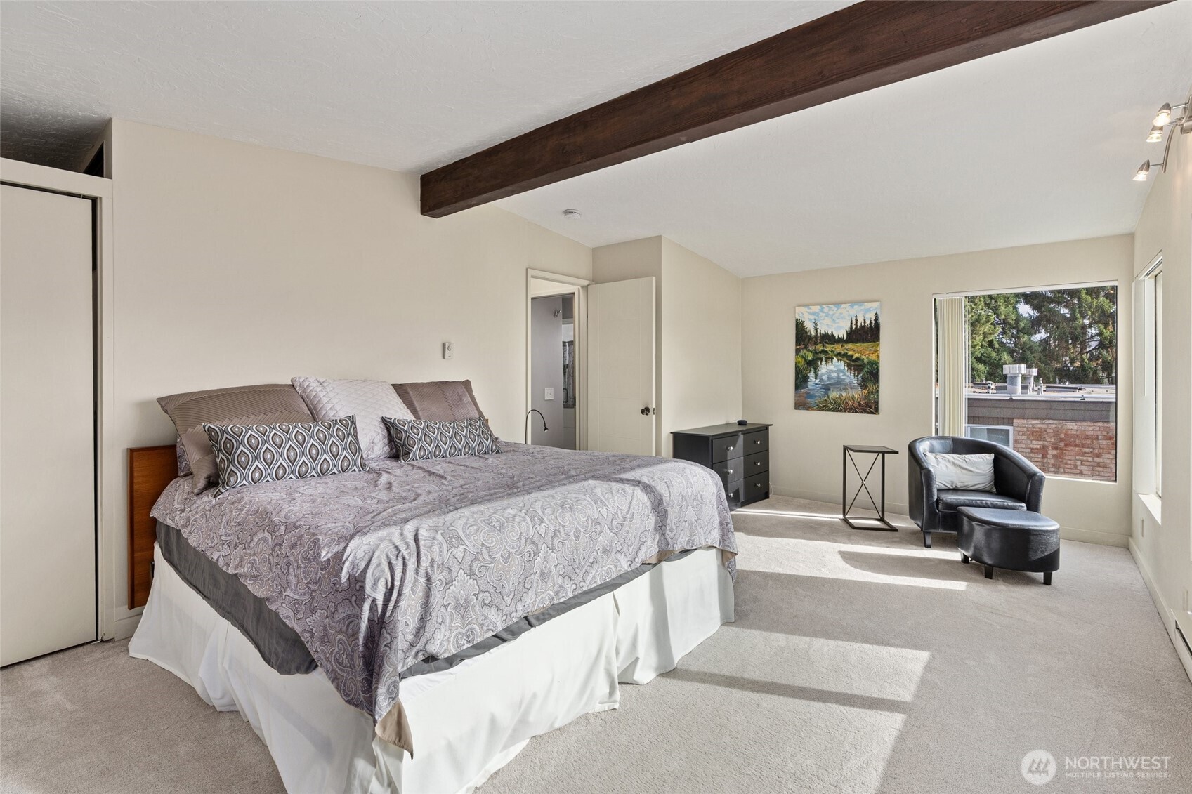 561 Lee Street Seattle, WA 98109 - Photo 19 of 40 a spacious bedroom with a bed a couch and large window