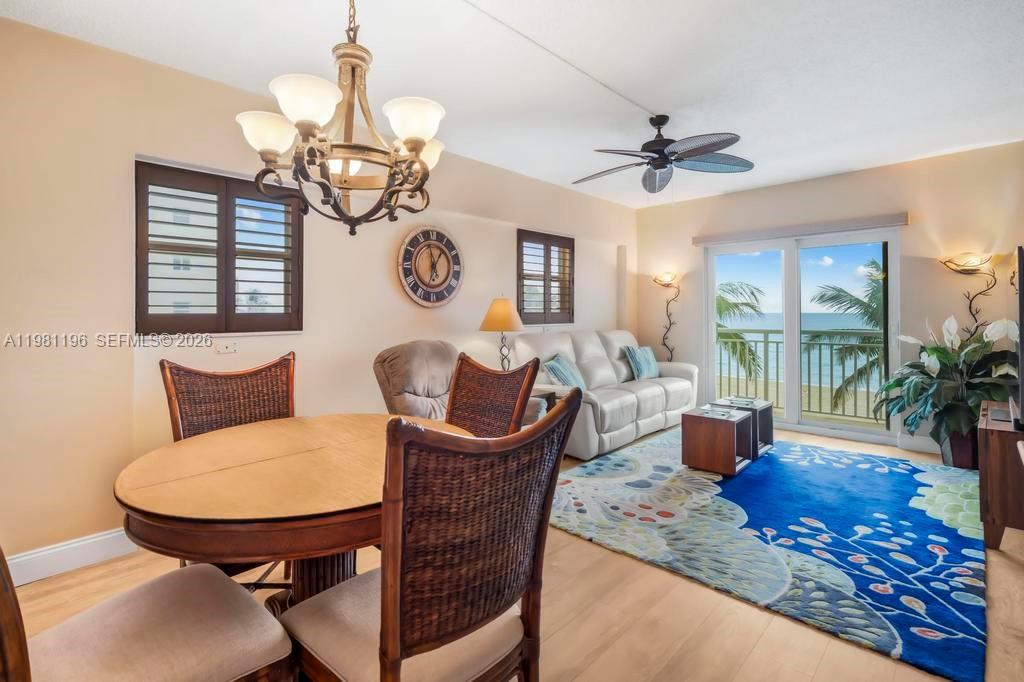 901 South Surf Road, Unit 408 Hollywood, FL 33019 - Photo 17 of 52 a dining room with wooden floor a chandelier a wooden table and chairs