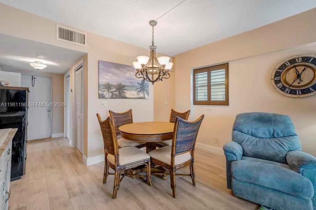 901 South Surf Road, Unit 408 Hollywood, FL 33019 - Photo 20 of 52 a dining room with furniture a chandelier and wooden floor