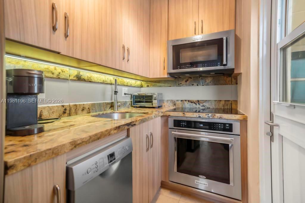 901 South Surf Road, Unit 408 Hollywood, FL 33019 - Photo 3 of 52 a kitchen with stainless steel appliances granite countertop a stove and a microwave