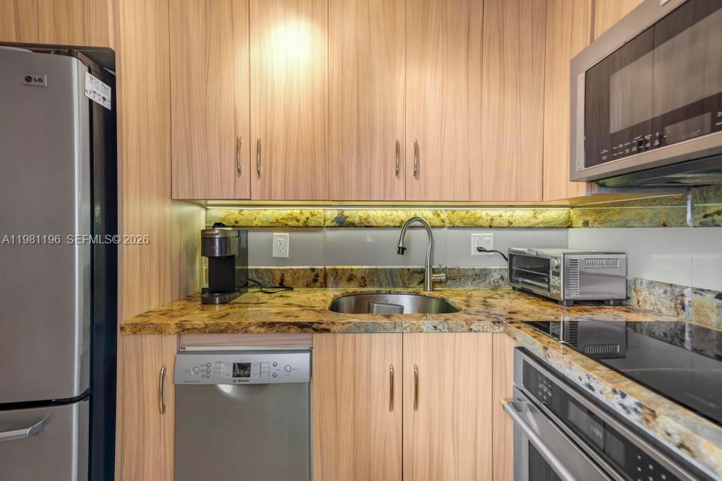 901 South Surf Road, Unit 408 Hollywood, FL 33019 - Photo 4 of 52 a kitchen with a sink a stove cabinets and a refrigerator
