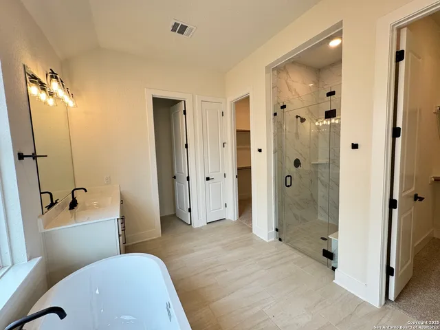 a spacious bathroom with a bathtub shower and toilet