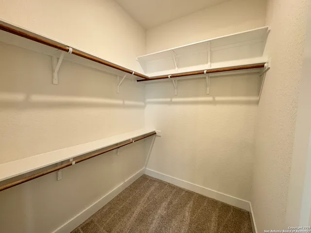 a view of walk in closet with empty racks