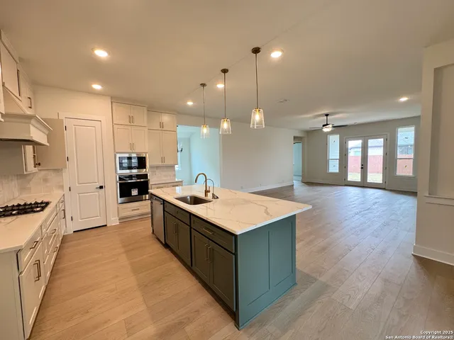 a kitchen with kitchen island a sink stove and wooden floor