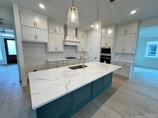 a kitchen with kitchen island white cabinets and stainless steel appliances