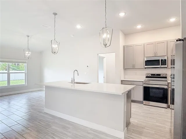 a kitchen with refrigerator a microwave and cabinets