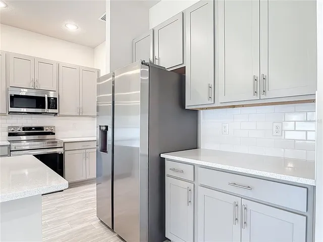 a kitchen with stainless steel appliances white cabinets and a sink