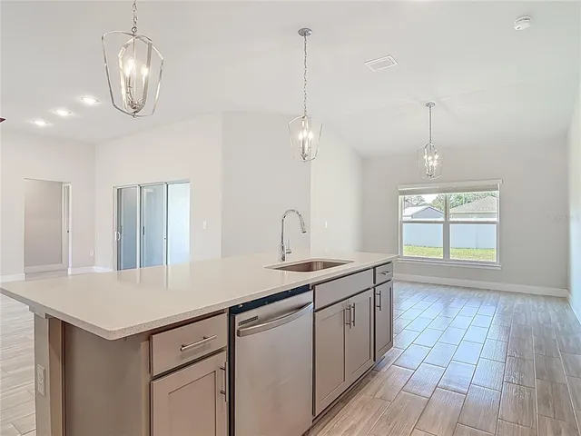 a kitchen with a sink a counter top space stainless steel appliances and cabinets