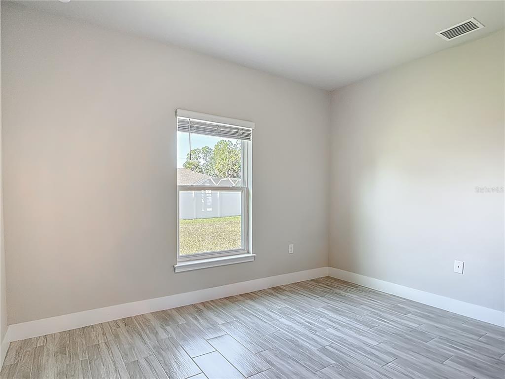 60 Ballenger Lane Palm Coast, FL 32137 - Photo 38 of 60 an empty room with wooden floor and windows