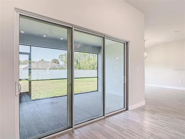 a kitchen with stainless steel appliances a stove a sink and white cabinets with wooden floor