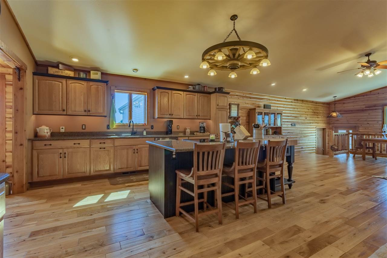 3517 North Marrill Road Byron, IL 61010 - Photo 11 of 36 a kitchen with stainless steel appliances granite countertop a stove top oven a refrigerator a dining table and chairs with wooden floor