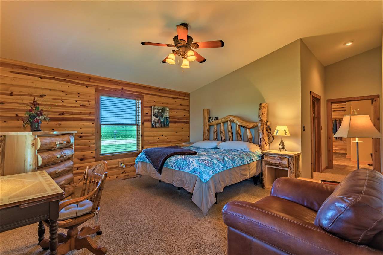 3517 North Marrill Road Byron, IL 61010 - Photo 23 of 36 a bedroom with two beds and a chandelier
