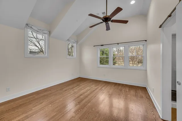 an empty room with windows and fan
