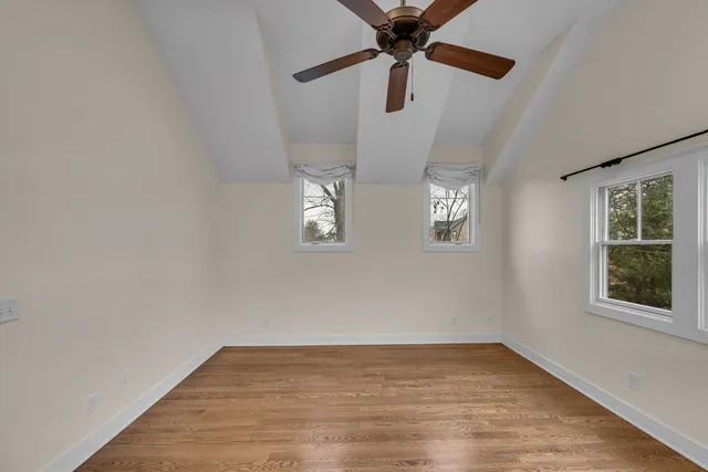 a view of empty room with wooden floor and window