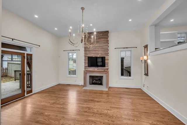 a view of a livingroom with wooden floor and a kitchen
