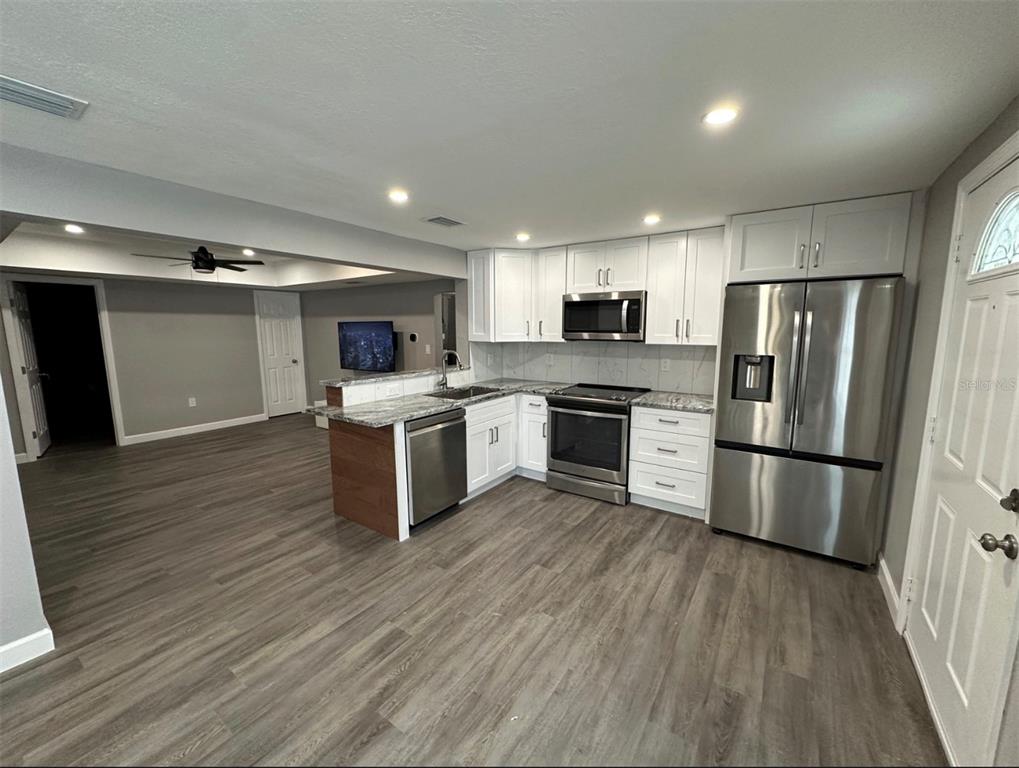 2301 Trelain Drive South St. Petersburg, FL 33712 - Photo 4 of 16 a kitchen with stainless steel appliances a refrigerator a stove top oven a sink and a refrigerator