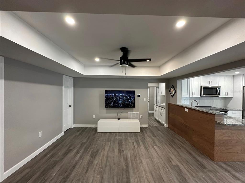 2301 Trelain Drive South St. Petersburg, FL 33712 - Photo 7 of 16 a living room with stainless steel appliances furniture a flat screen tv and a kitchen view