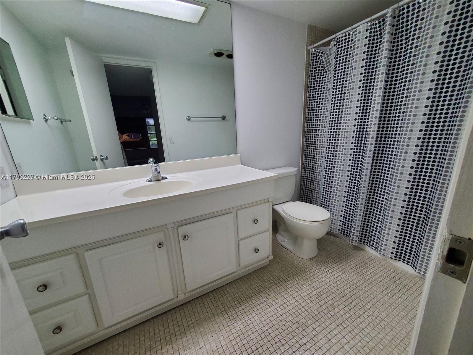 2900 North Palm Aire Drive, Unit 108 Pompano Beach, FL 33069 - Photo 14 of 17 a bathroom with a double vanity sink toilet and mirror