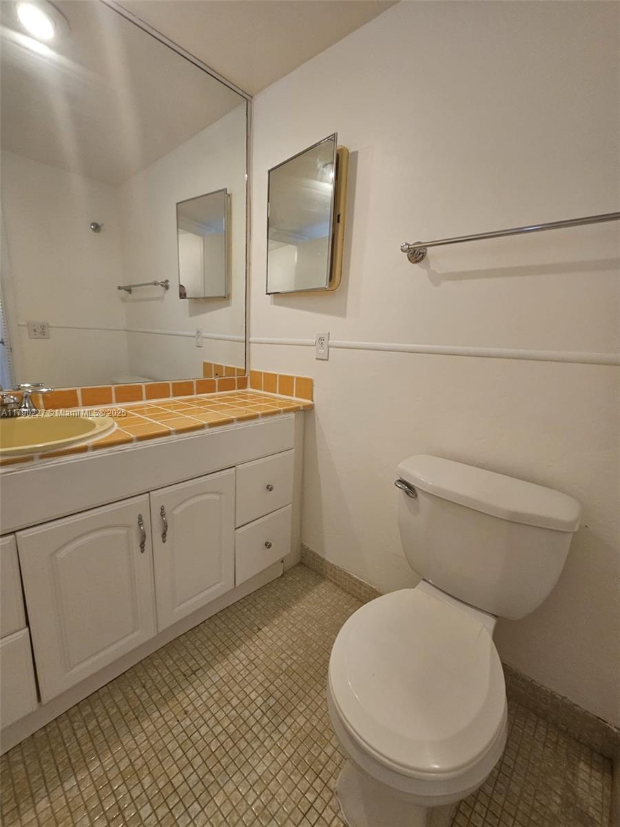 2900 North Palm Aire Drive, Unit 108 Pompano Beach, FL 33069 - Photo 15 of 17 a bathroom with a toilet sink and mirror