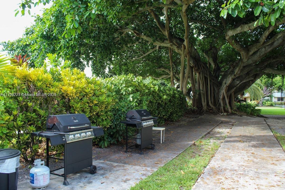 2900 North Palm Aire Drive, Unit 108 Pompano Beach, FL 33069 - Photo 17 of 17 a view of a patio with table and chairs and potted plants