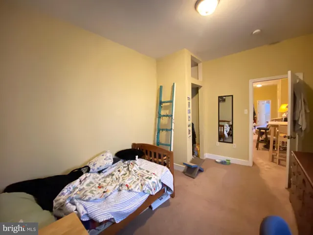 a bed sitting in a spacious bedroom next to a window