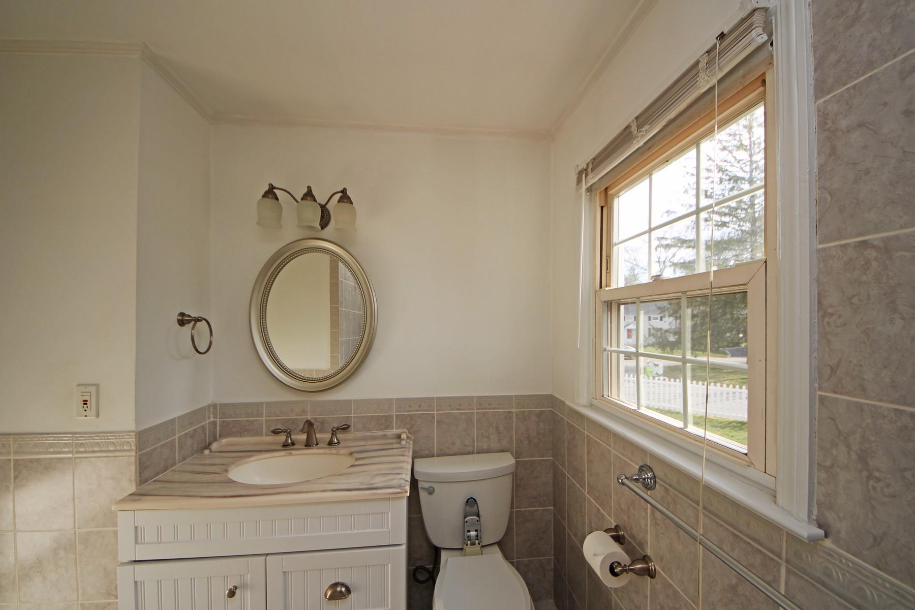 68 Maple Street Darien, CT 06820 - Photo 13 of 25 a bathroom with a granite countertop toilet a sink and a mirror
