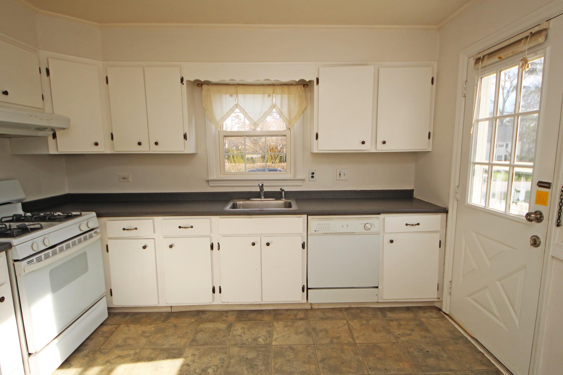 68 Maple Street Darien, CT 06820 - Photo 6 of 25 a white kitchen with granite countertop white cabinets and window