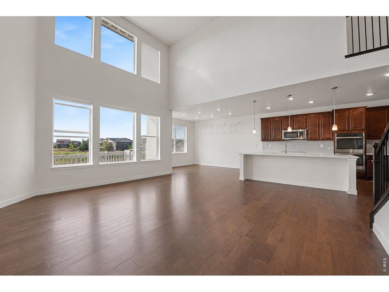 7139 Stratus Road Timnath, CO 80547 - Photo 27 of 27 Bright open floor plan with floor-to-ceiling windows overlooking water views (digitally altered to appear empty)