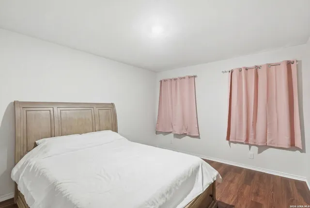 a large bed sitting in a bedroom next to a window