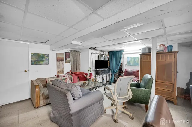 a living room with furniture a kitchen view and a wooden floor