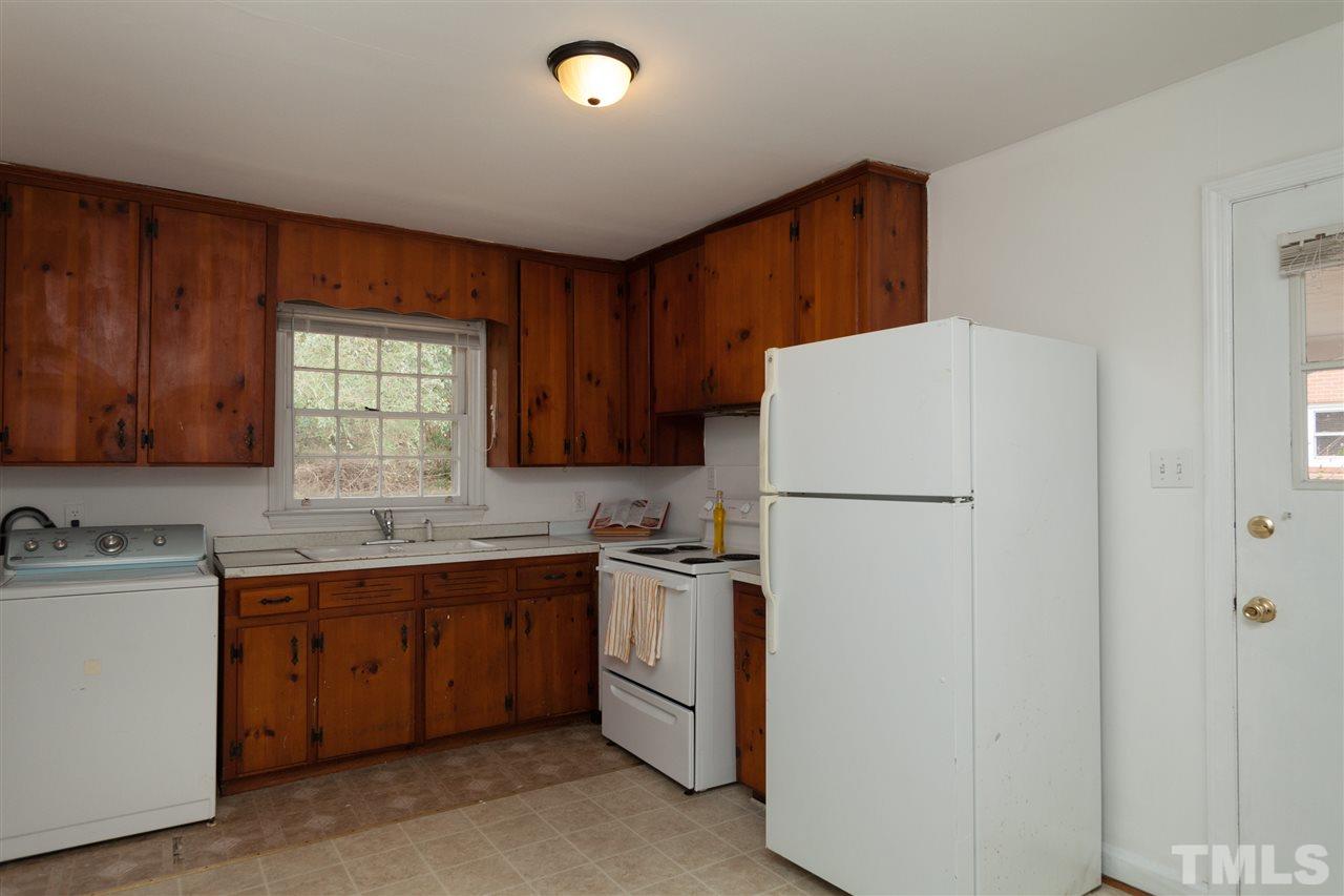 3105 Brentwood Road Raleigh, NC 27604 - Photo 12 of 25 a kitchen with a sink a refrigerator and cabinets