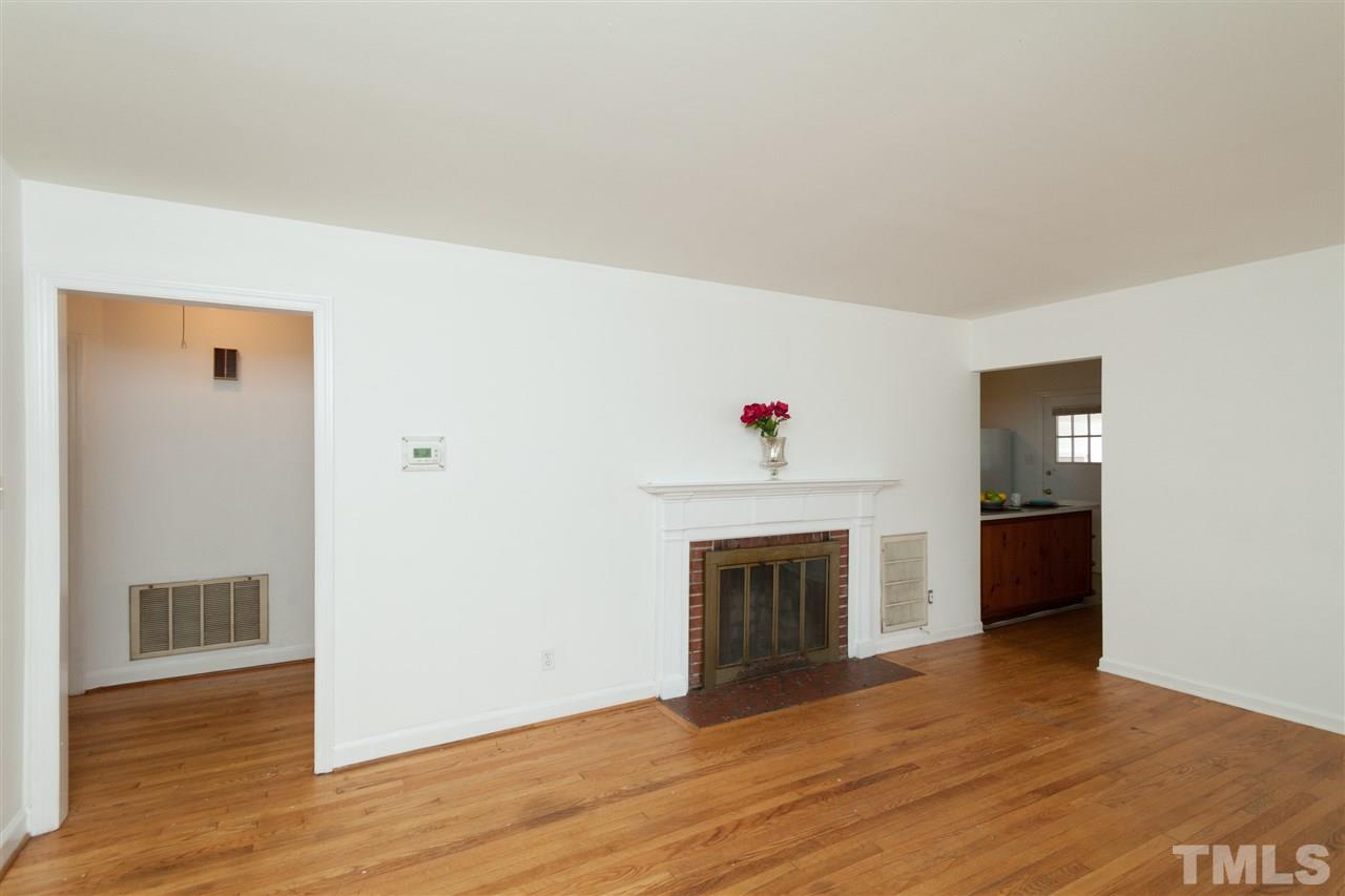 3105 Brentwood Road Raleigh, NC 27604 - Photo 5 of 25 a view of an empty room with wooden floor and fireplace