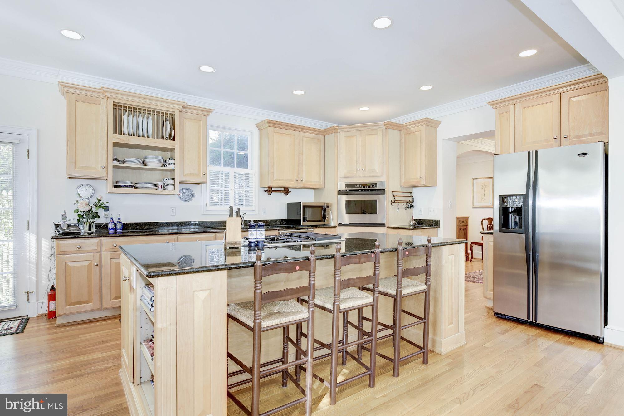 5220 Elliott Road Bethesda, MD 20816 - Photo 11 of 30 a kitchen with stainless steel appliances granite countertop a stove a sink a refrigerator and white cabinets with wooden floor